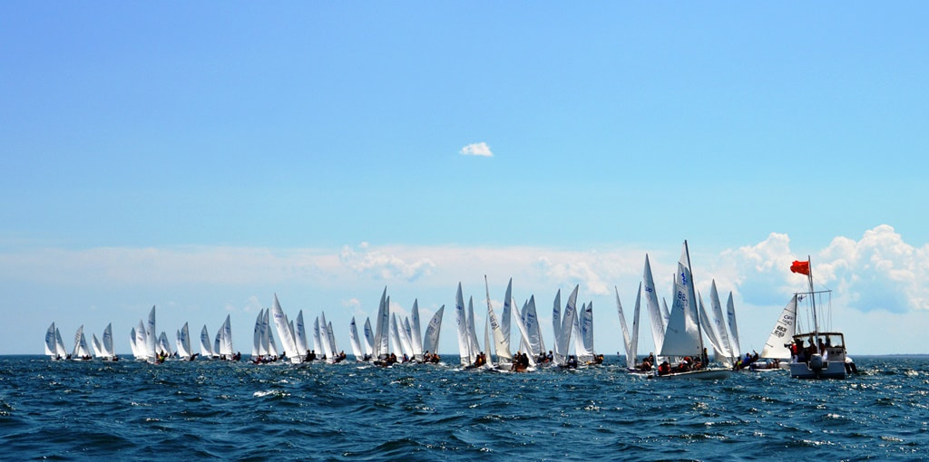 A fleet of junior sailboats racing off the Maine coast